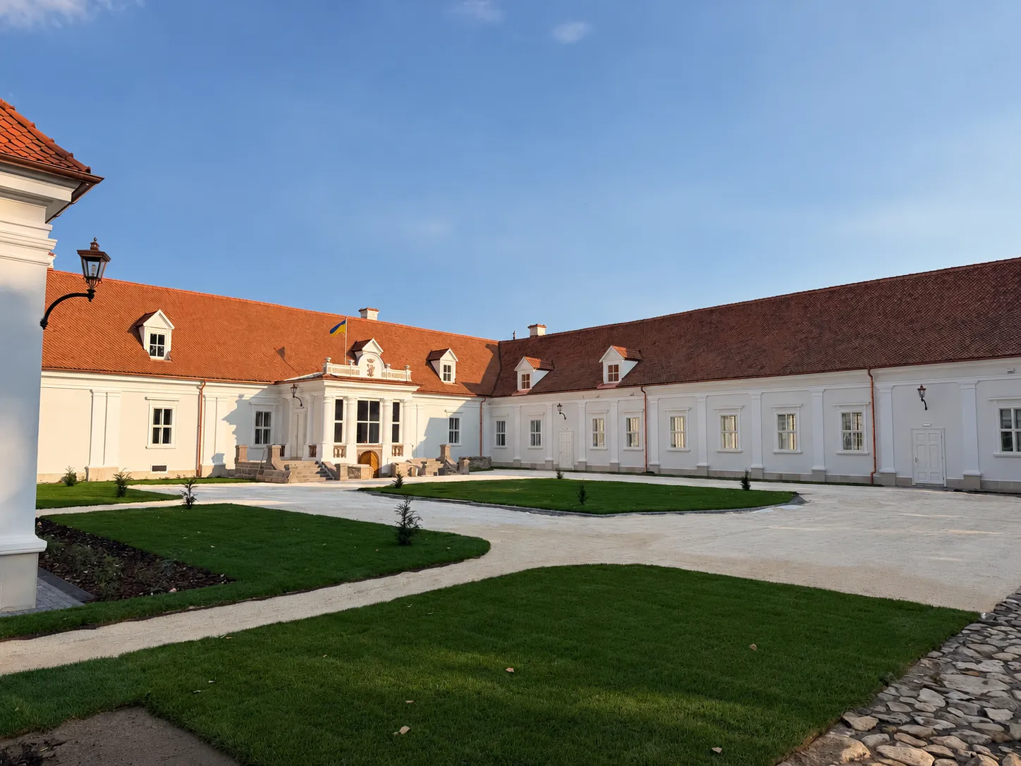 Courtyard and white facades of Kőröspatak Castle