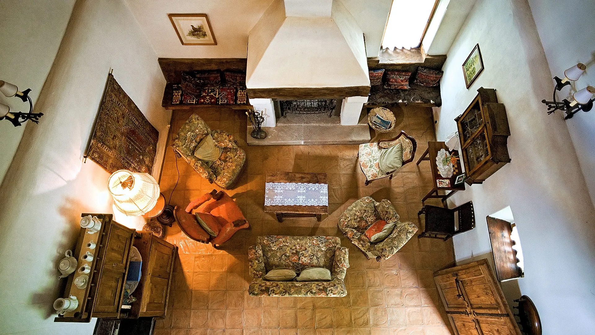 Overhead view of a traditional sitting room at Zalánpatak, with a fireplace and patterned furniture.